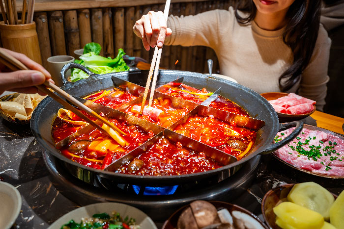 Experiencia gastronómica auténtica en Chongqing: disfrutando de un tradicional Hot Pot picante. Una imagen ideal para artículos sobre gastronomía china y cultura culinaria de Sichuan